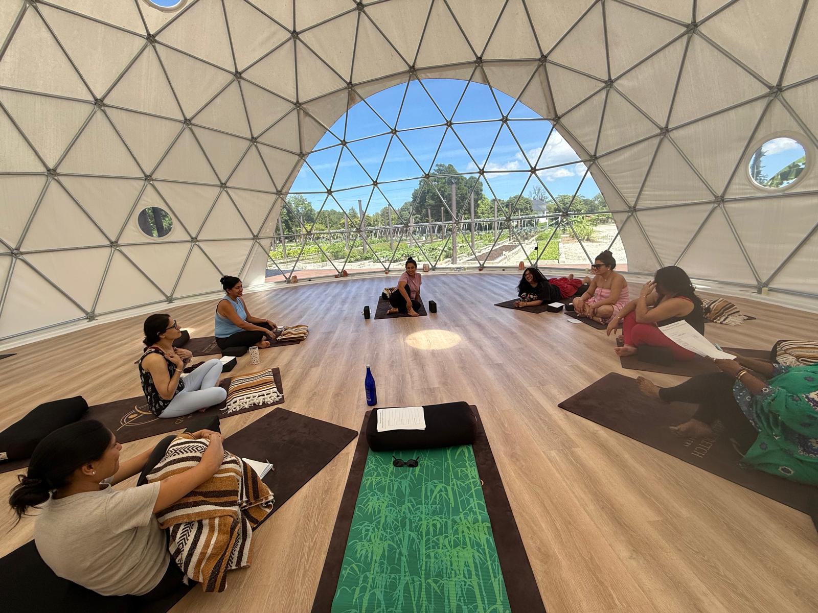 Retreat attendees gathered in a circle on yoga mats inside the meditation dome